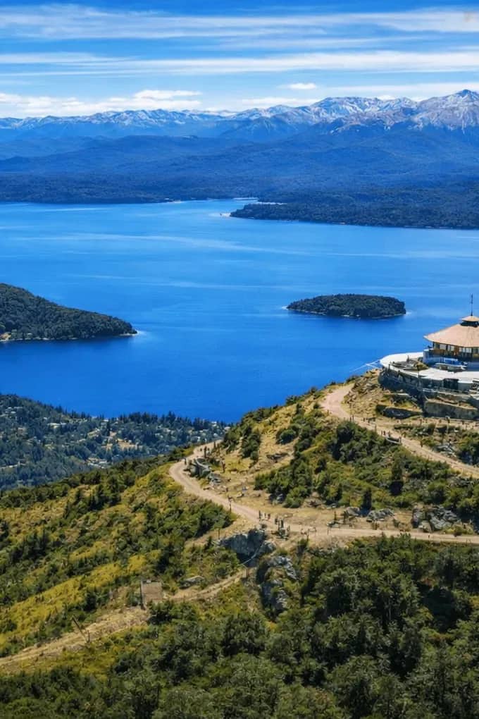 Vista panorámica desde la cumbre del Cerro Otto con la confitería giratoria y el lago Nahuel Huapi rodeado de montañas y bosques, Bariloche.