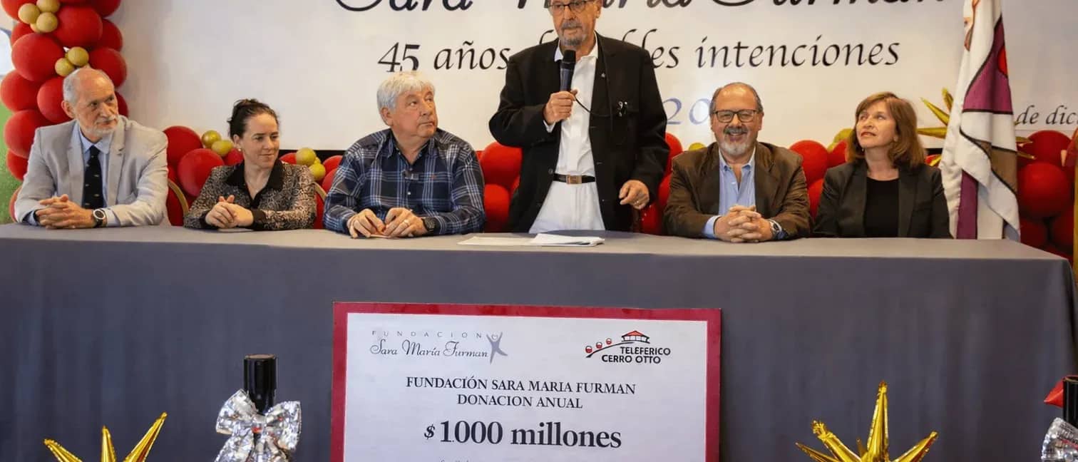 Integrantes de la fundacion dando un discurso con el cartel que muestra la dondacion realizada por un monto total de 1 millon de pesos argentinos
