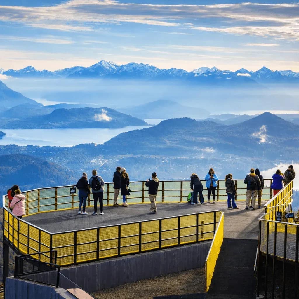 Mirador del Cerro Otto con visitantes observando el paisaje de montañas y lagos de Bariloche